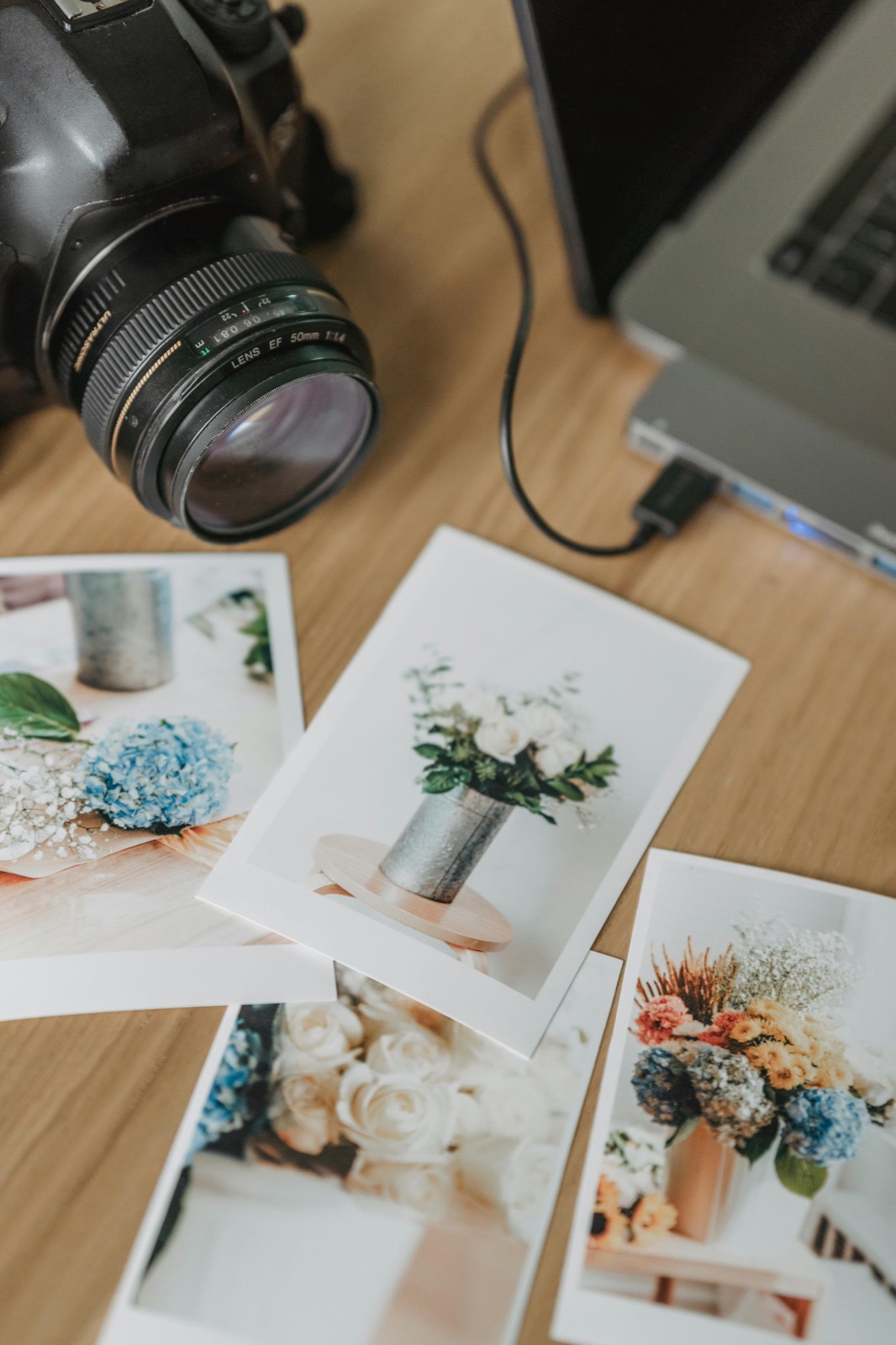 Printed event photographs and camera detail on a table